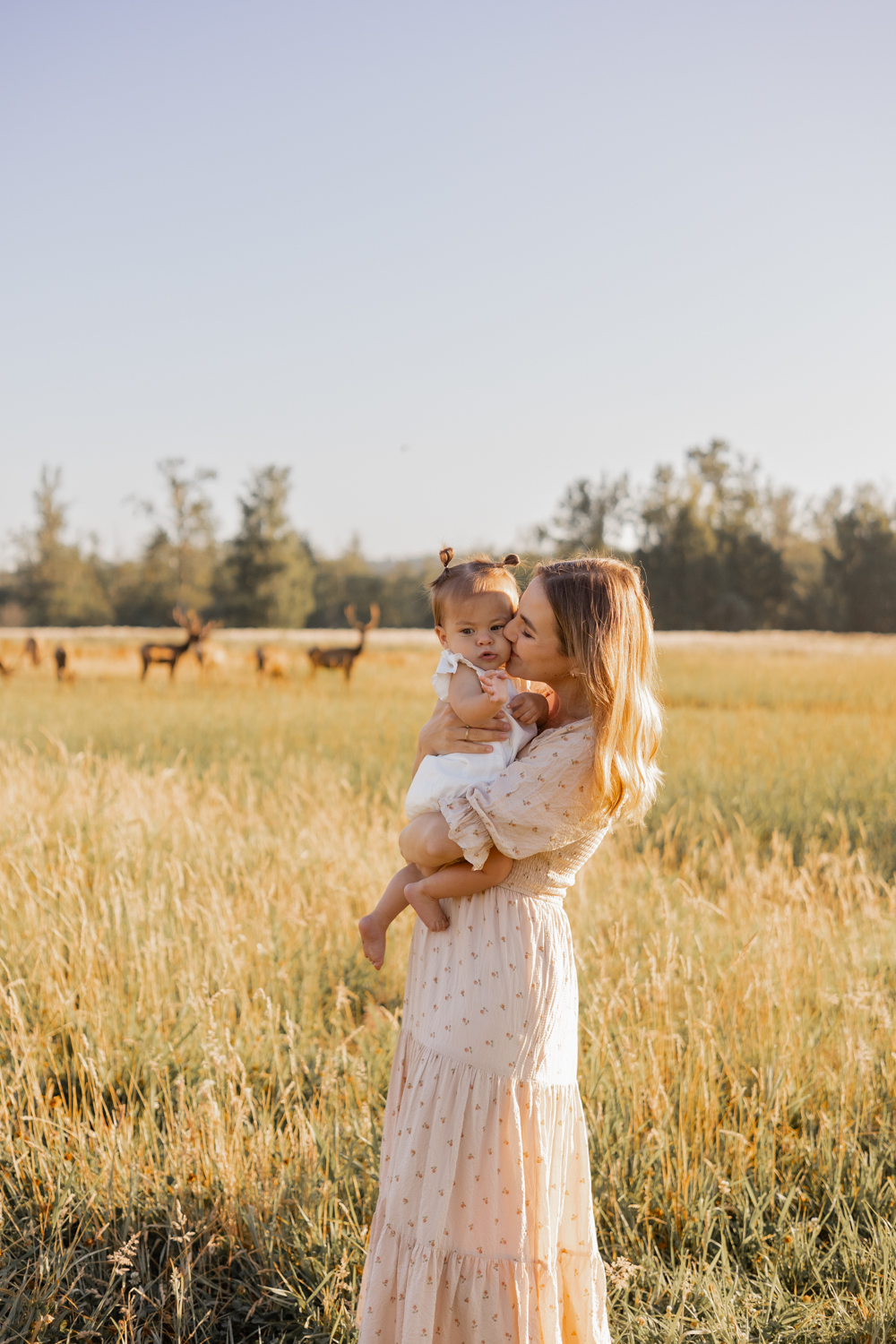 motherhood photography session captures mom and baby girl in a field in the PNW with Elk