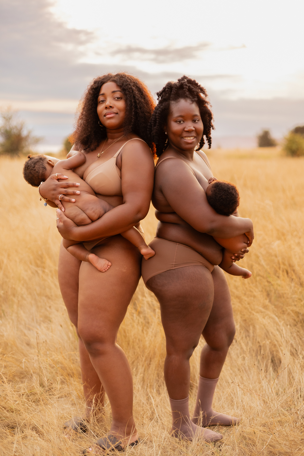 two women of color breastfeeding their babies for a raw motherhood photography session