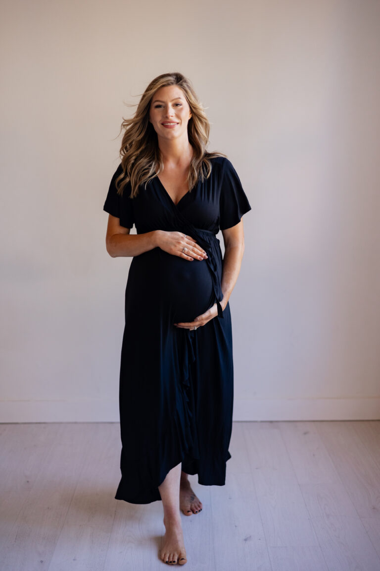pregnant model showing client closet options for maternity photography