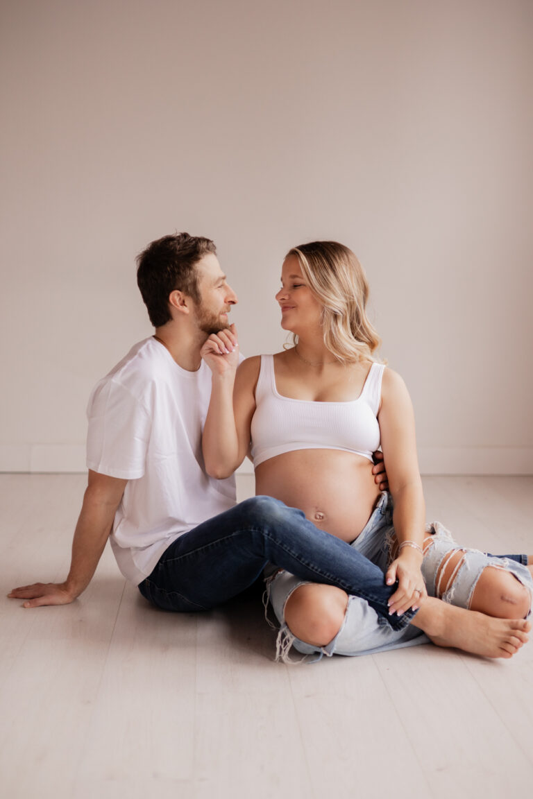 Couple posing in Seattle studio for maternity photoshoot