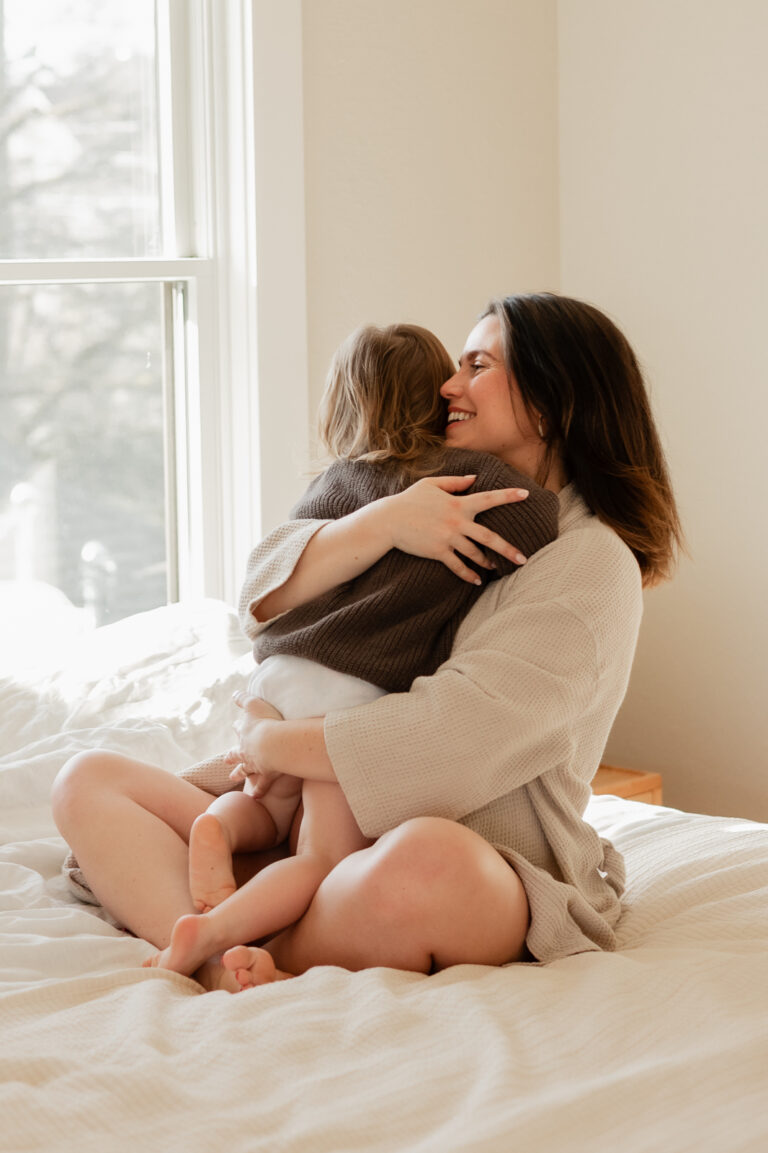 Pregnant mom hugs toddler during in home maternity session in Seattle