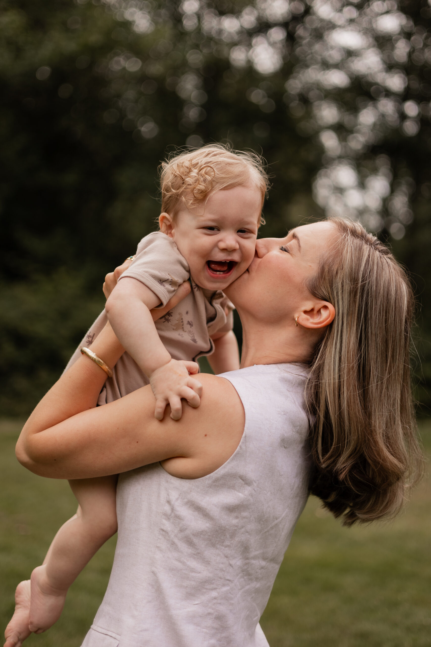 Mother kisses her toddler son during family photoshoot in Bothell, WA